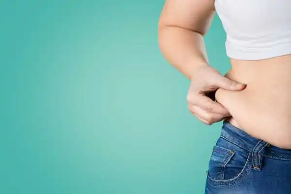 Image of woman pinching her love handles to show weight gain Malvern Link